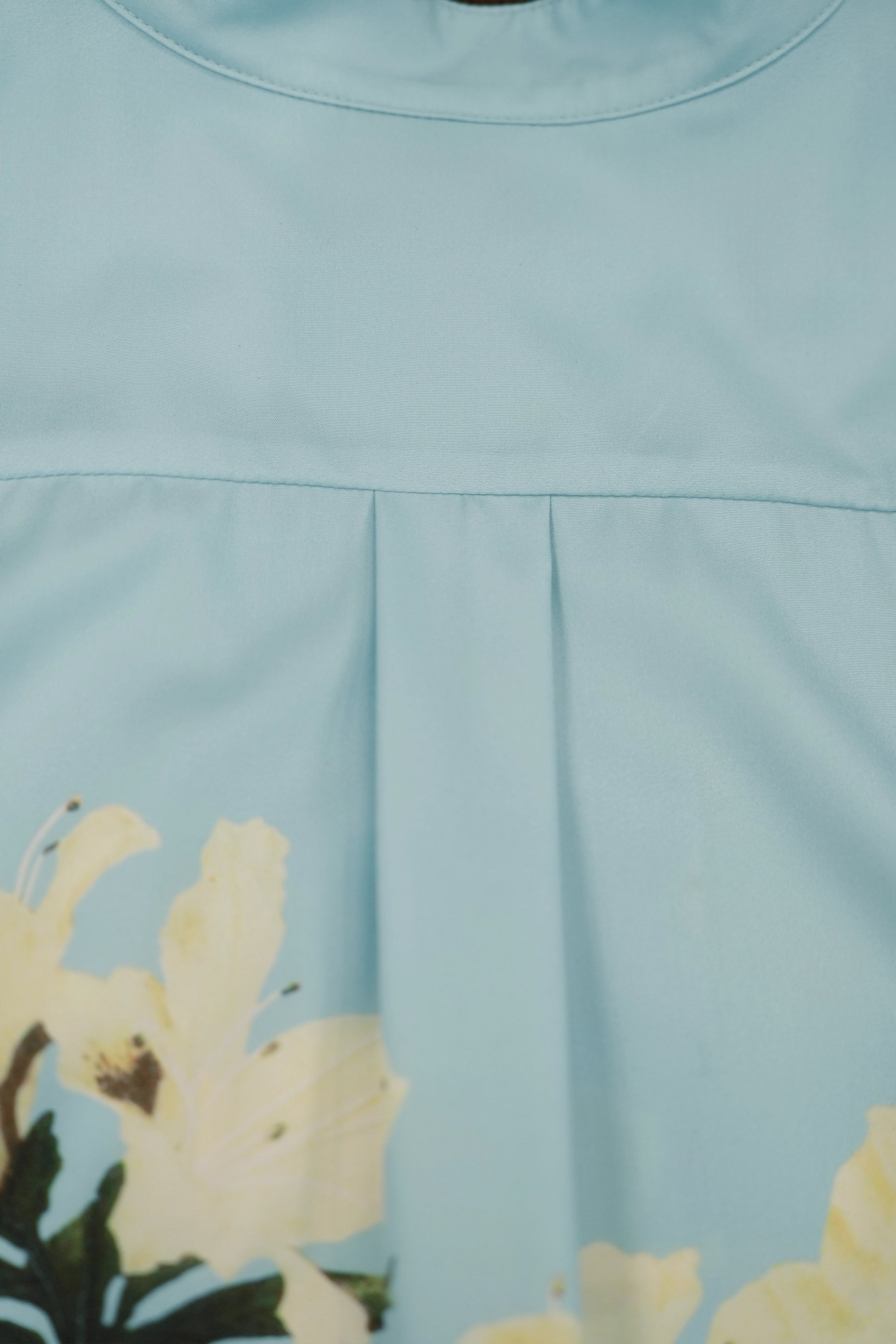 Close-up of back yoke and pleat detail on light blue micro Chinese collar top showing soft structure and drape