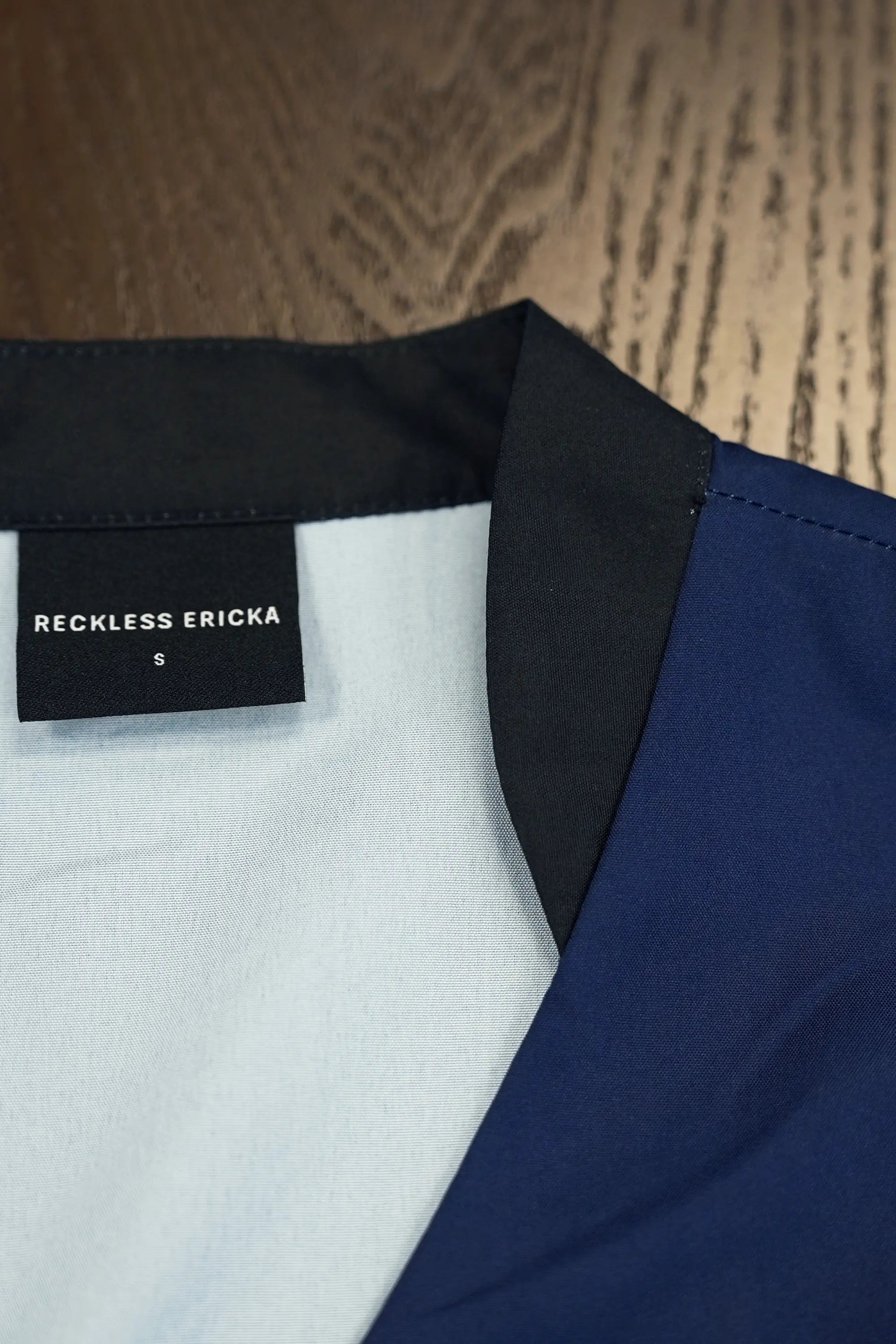 Close-up of inner neckline featuring contrast black lapel detail, showcasing clean finishing and smooth fabric construction