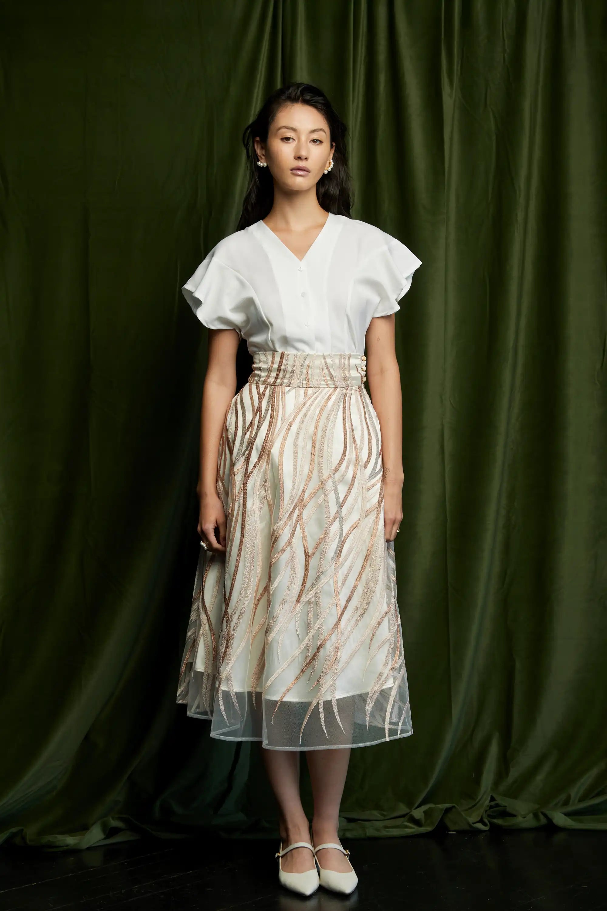 White flutter sleeve peplum top with button front paired with sheer embroidered midi skirt featuring abstract linear prints, full front view