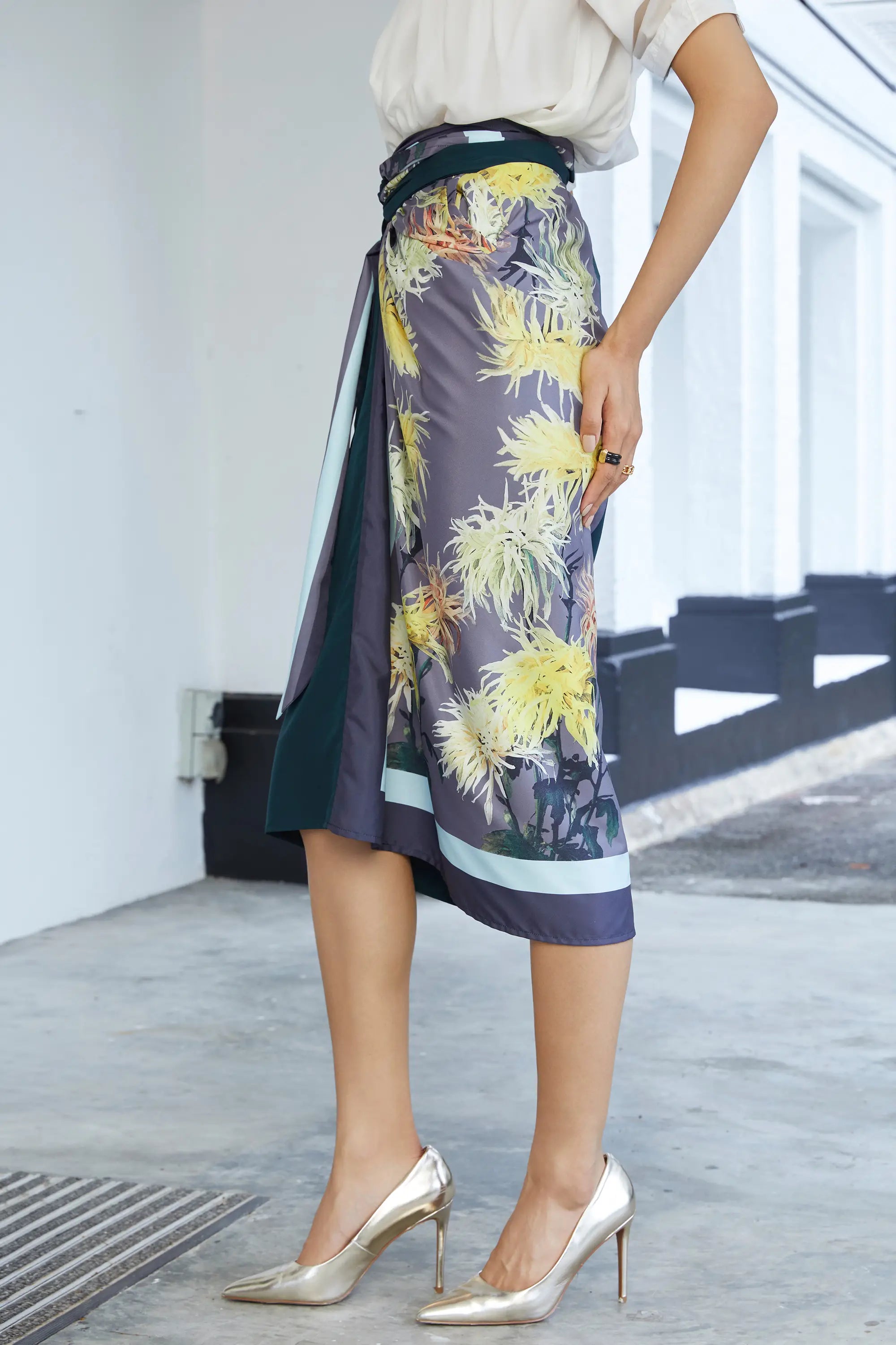 Side view of wrap skirt showing layered construction, soft drape, and waist sash tying for a custom fit