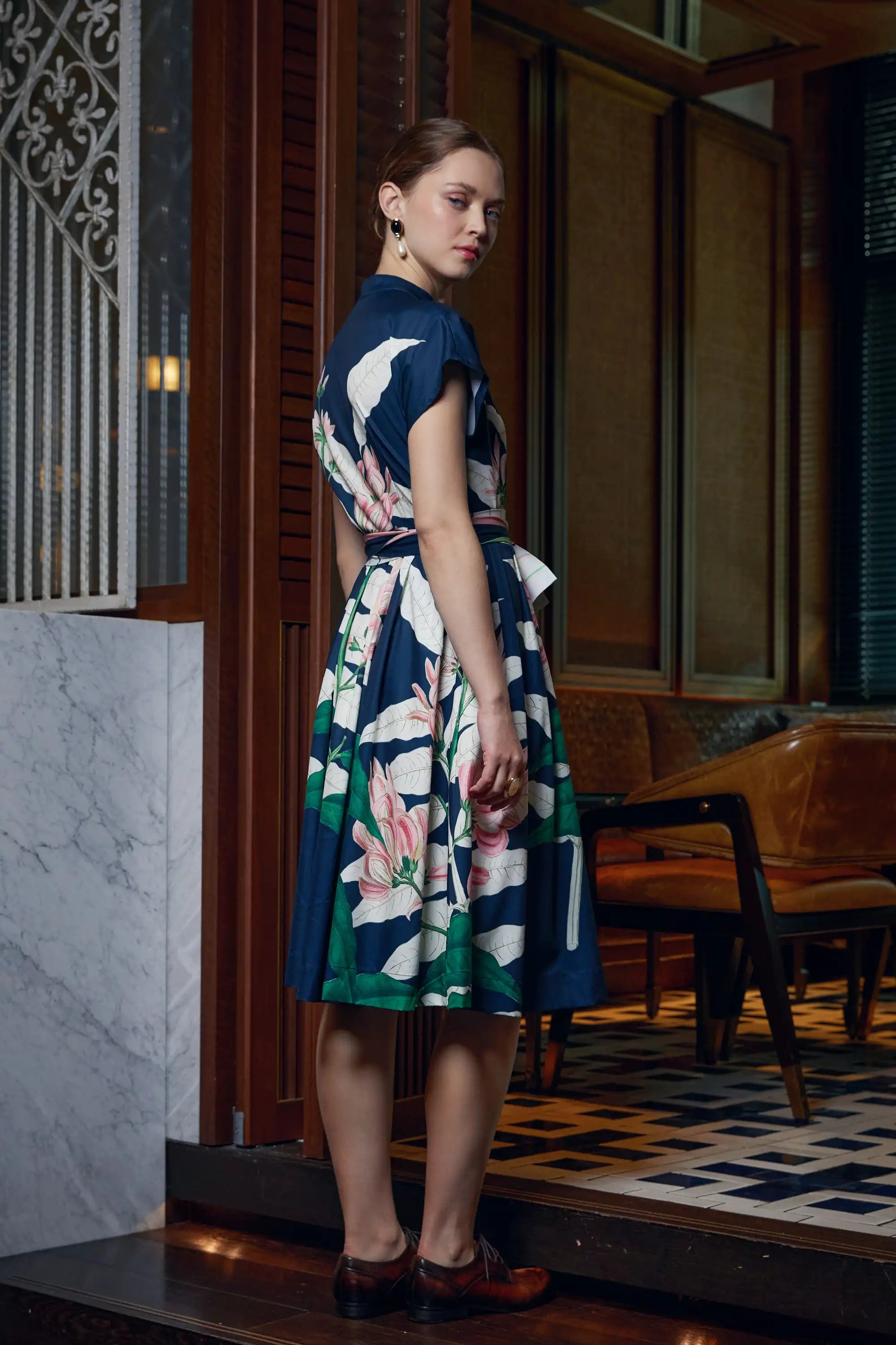 Woman wearing Arrayed navy Geoffroya Inermis print midi dress with full skirt, side view