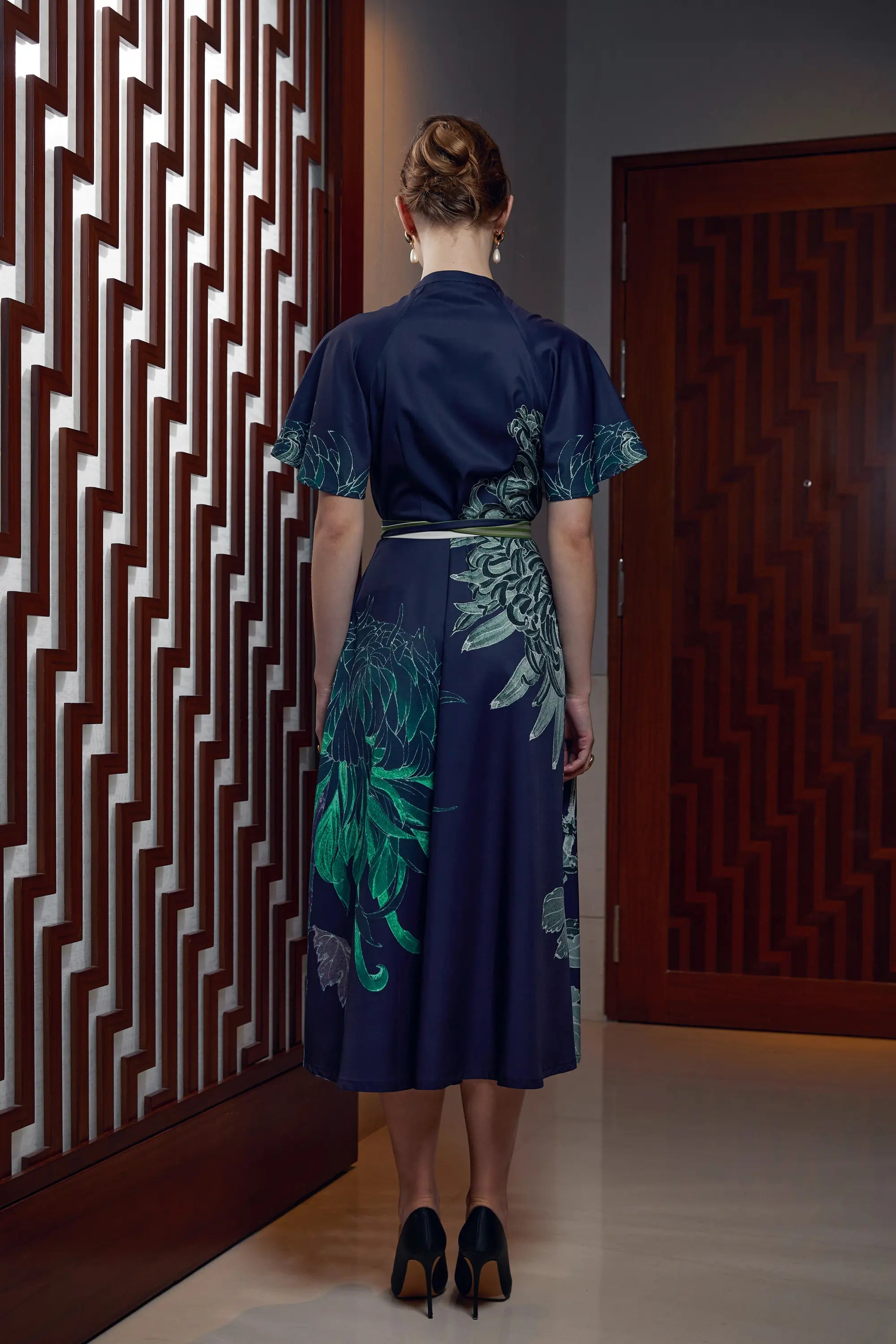 Woman wearing Arrayed Chrysanthemum print flutter sleeve maxi dress in navy, back view