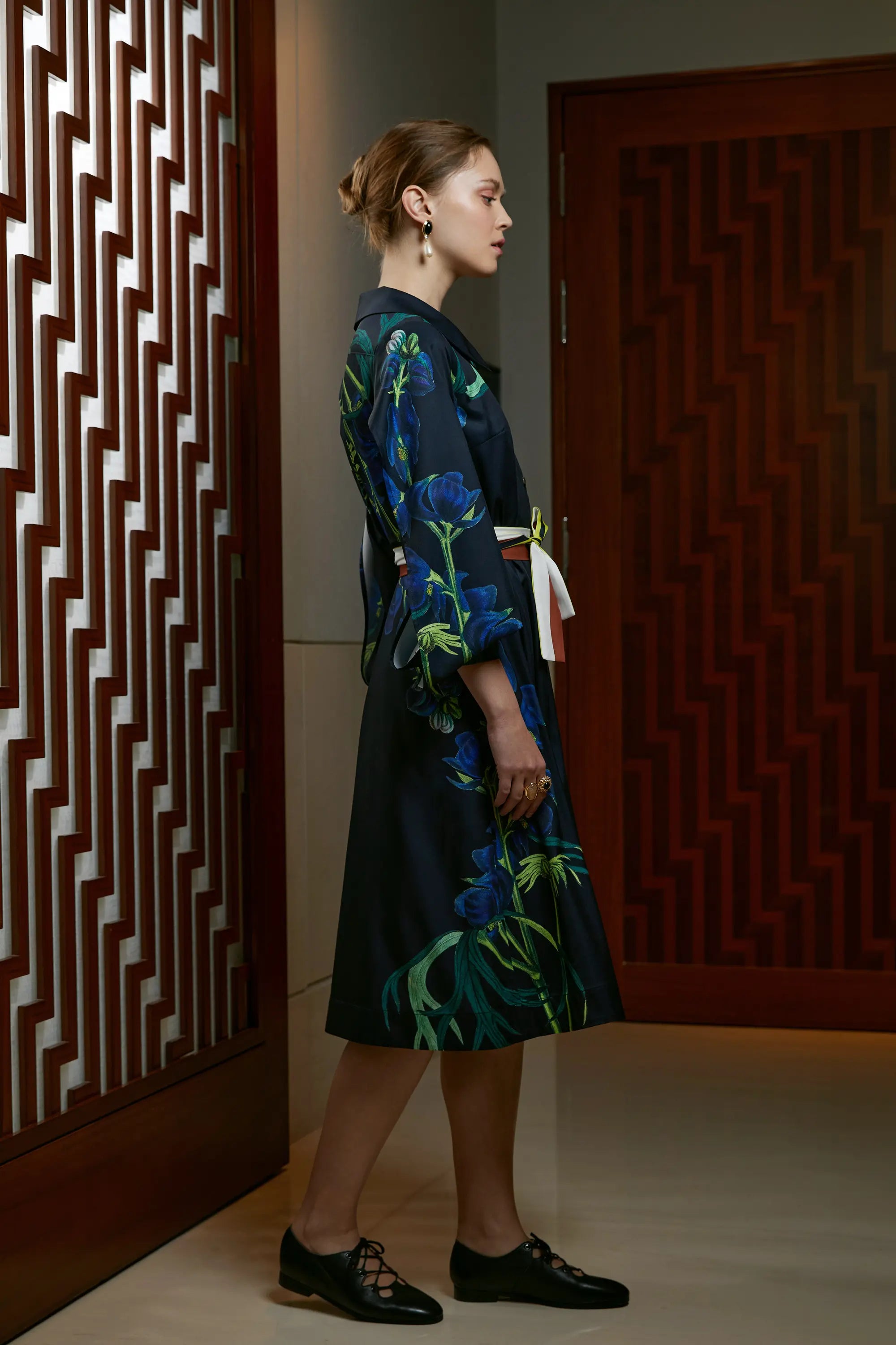 Woman wearing Arrayed Monk's Hood shirt dress with folded sleeves, side view