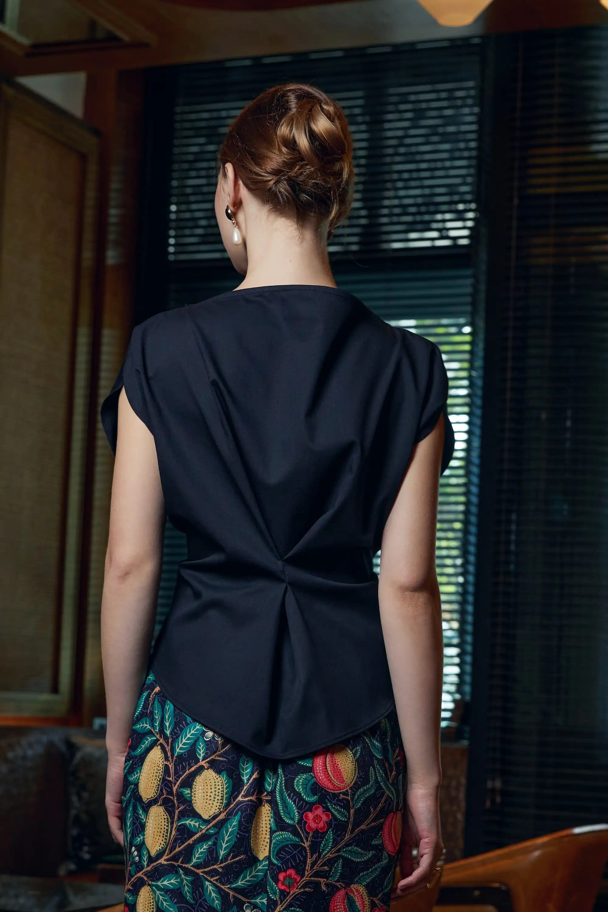 Woman wearing Arrayed black adjustable top, back view
