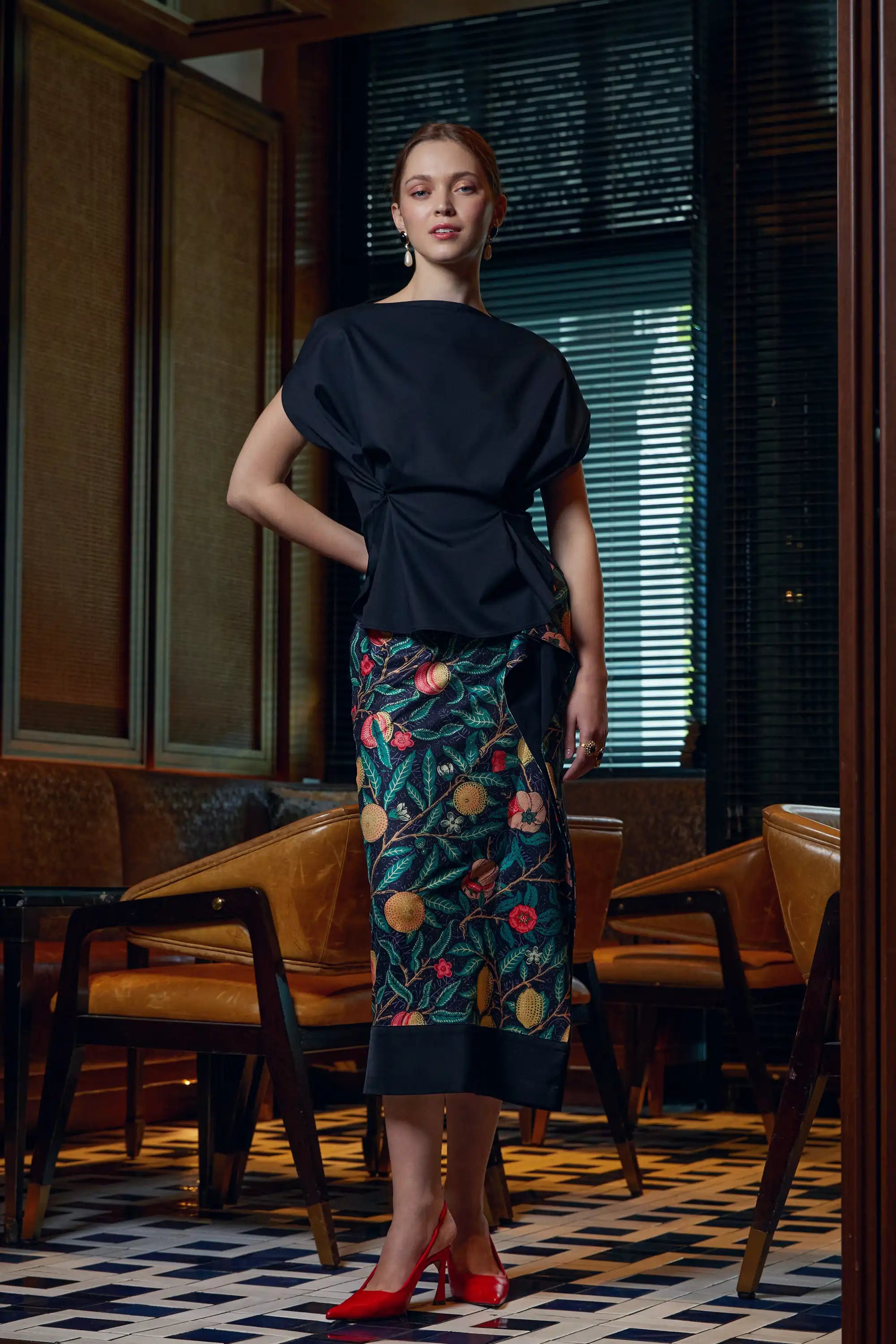 Woman wearing adjustable black top with Arrayed black Pomegranate print ribbed midi skirt