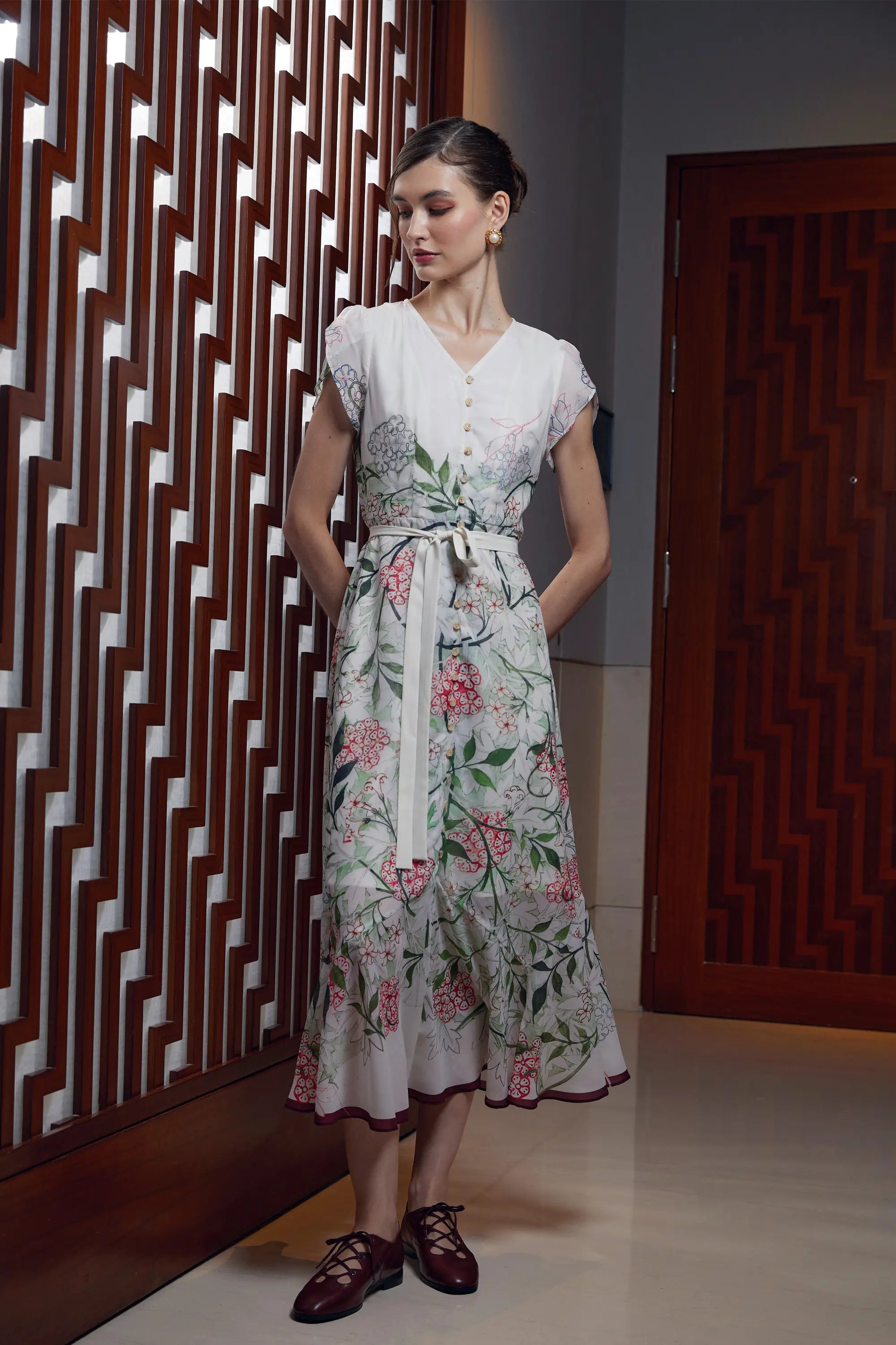 Woman wearing Reckless Ericka Arrayed Jasmine print petal sleeve mermaid maxi dress in ivory, front view