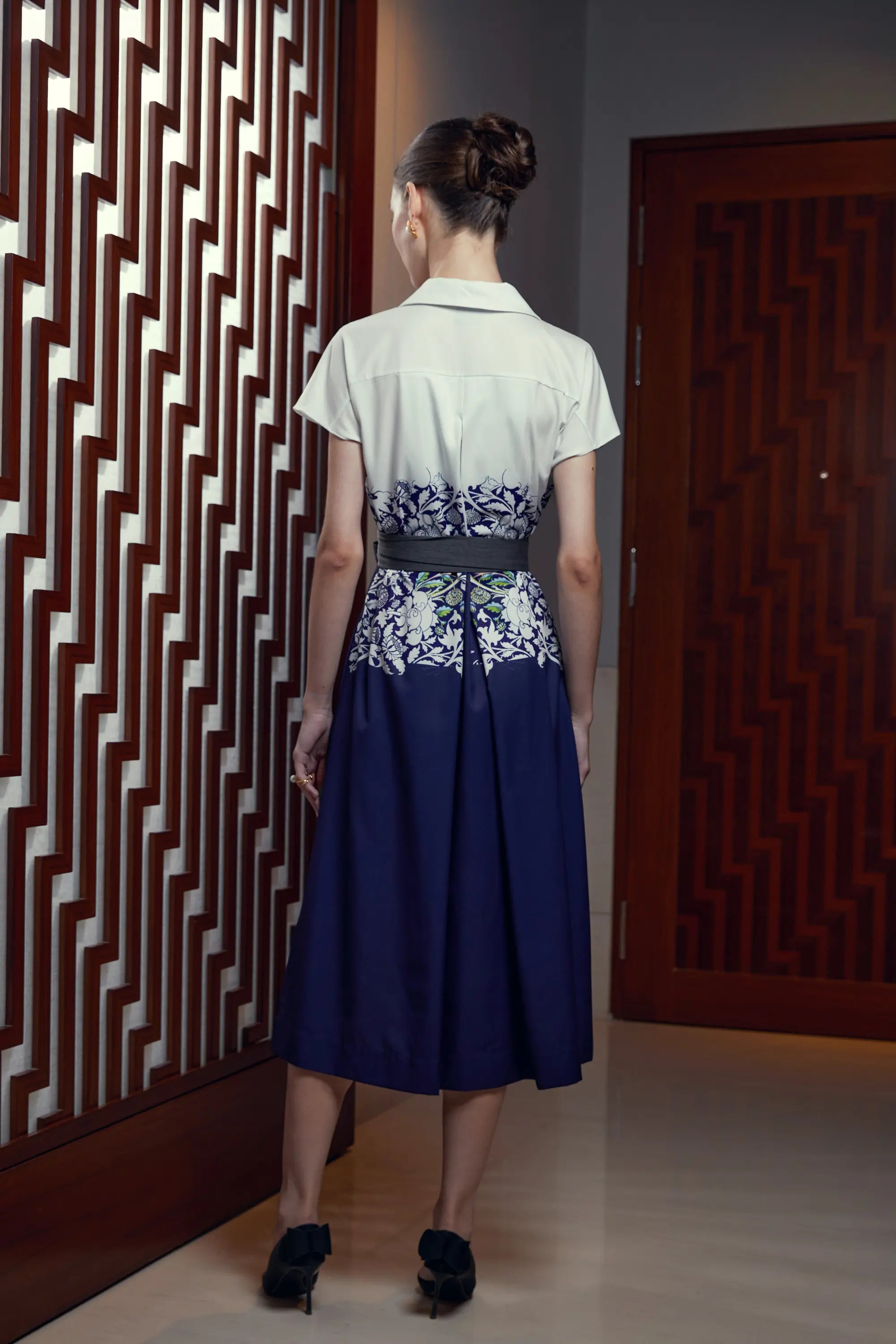 Woman wearing Arrayed Peony print trench midi dress in ivory, back view