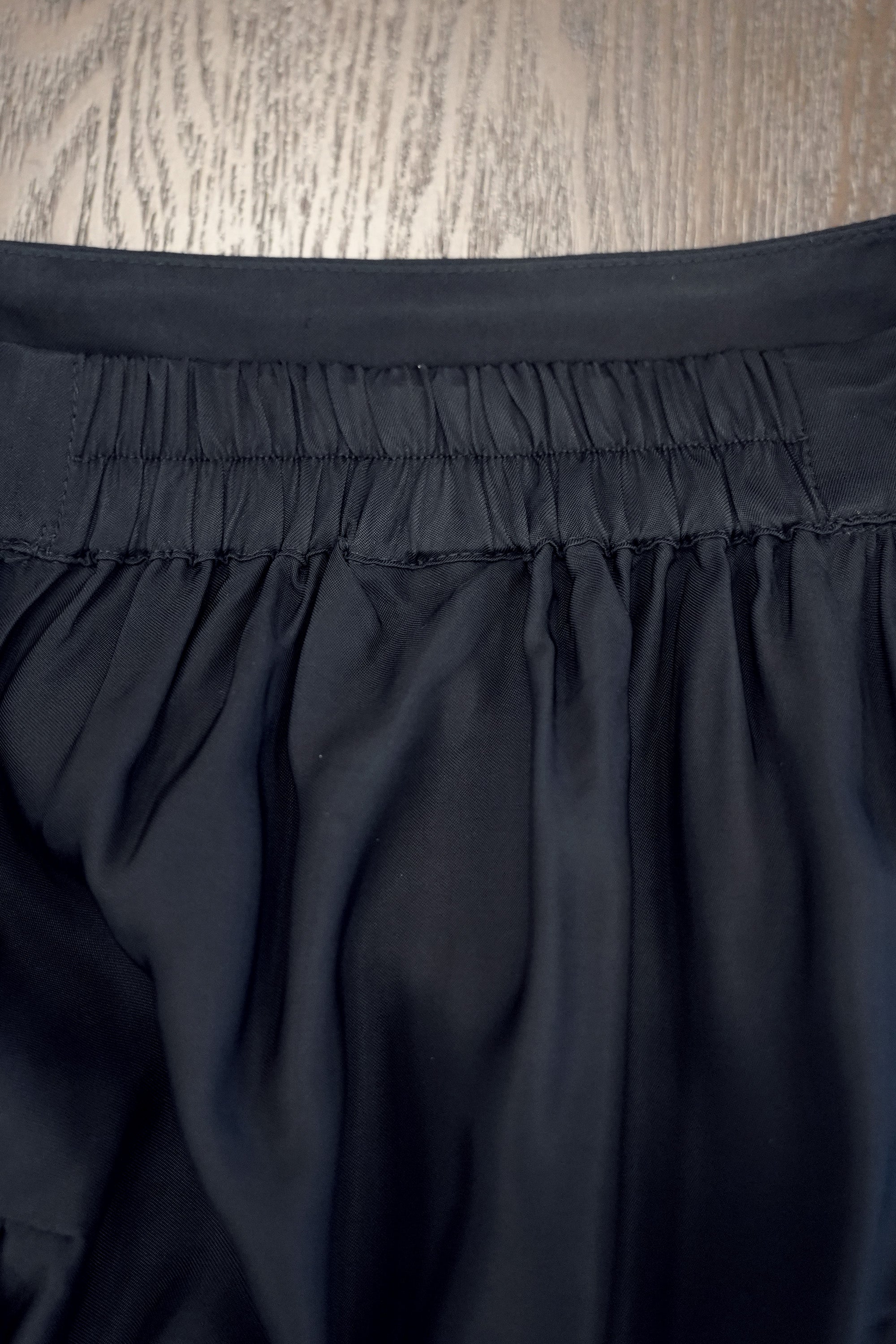Close-up of billowing skirt showcasing elasticated waistband with soft gathers, designed for comfort while maintaining a clean, structured finish