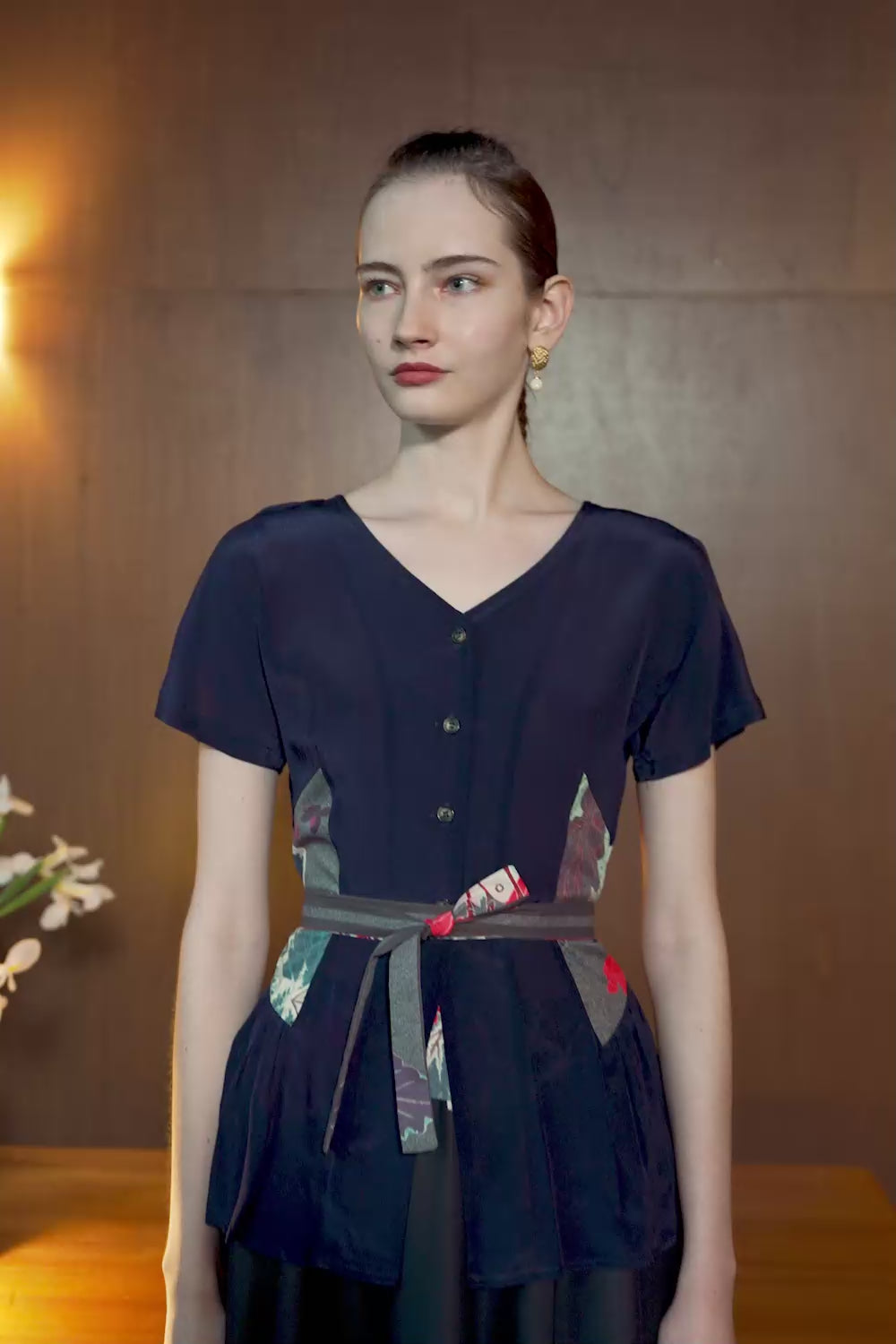Model wearing Cracklin' Rosie Begonia top with sculpted darts and flared hem, in motion