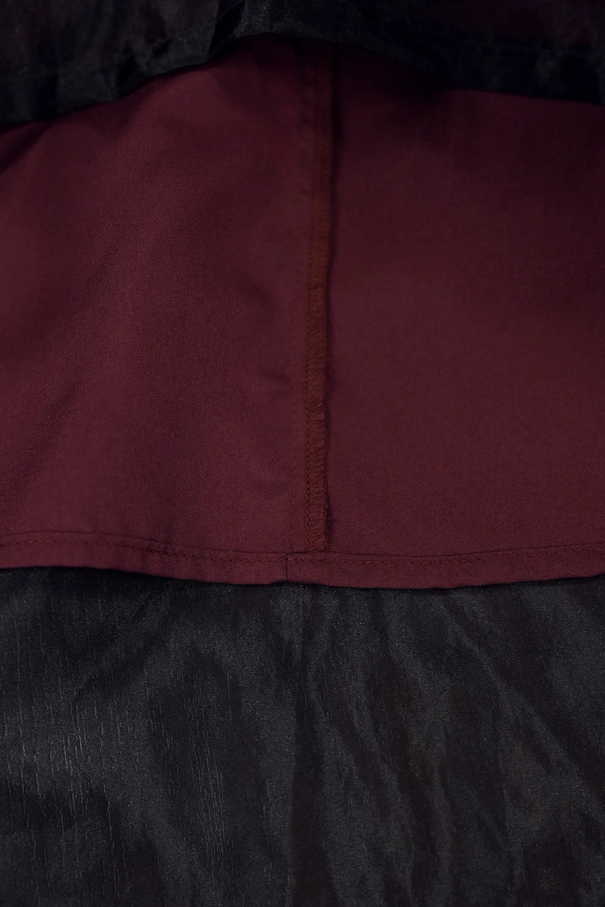 Close-up of skirt underside highlighting inner lining and seam construction, showcasing clean finishing, soft fabric texture, and layered structure beneath the sheer overlay