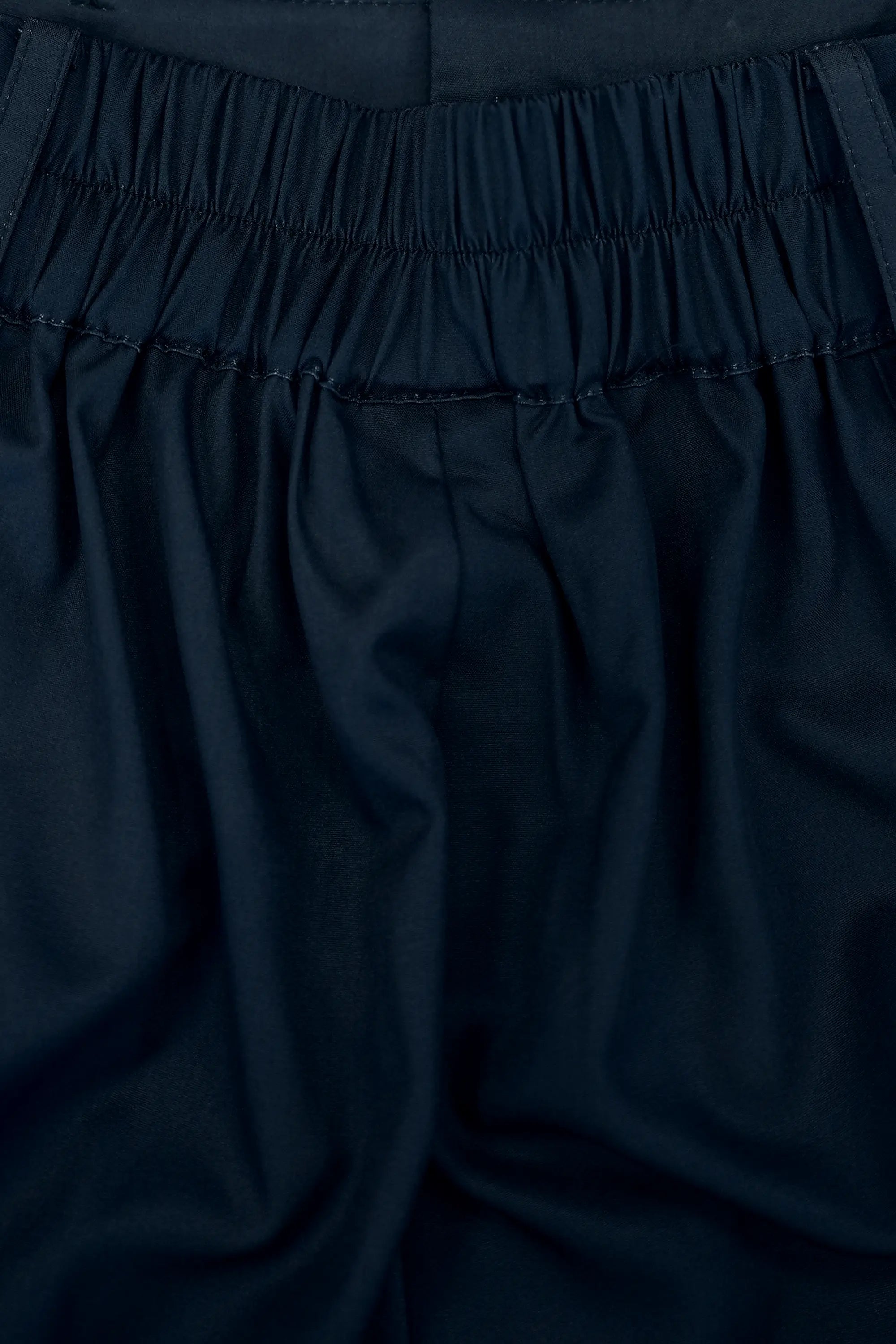 Close-up of waistband featuring elastic ruching, highlighting gathered detailing, flexible fit, and clean stitching for comfort and structure