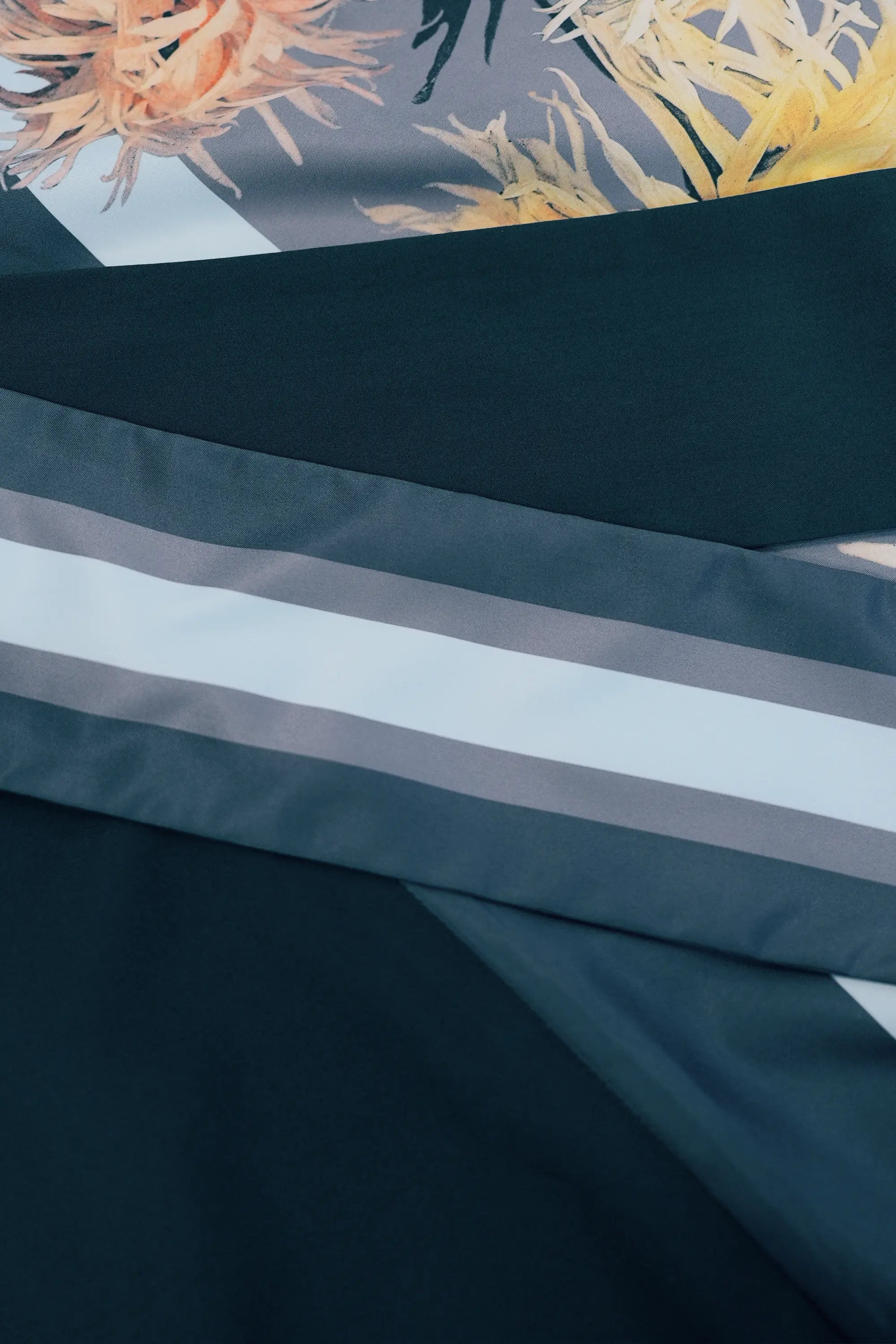 Close-up of contrast sash detail with layered stripes, combining solid and printed panels for a refined, graphic finish