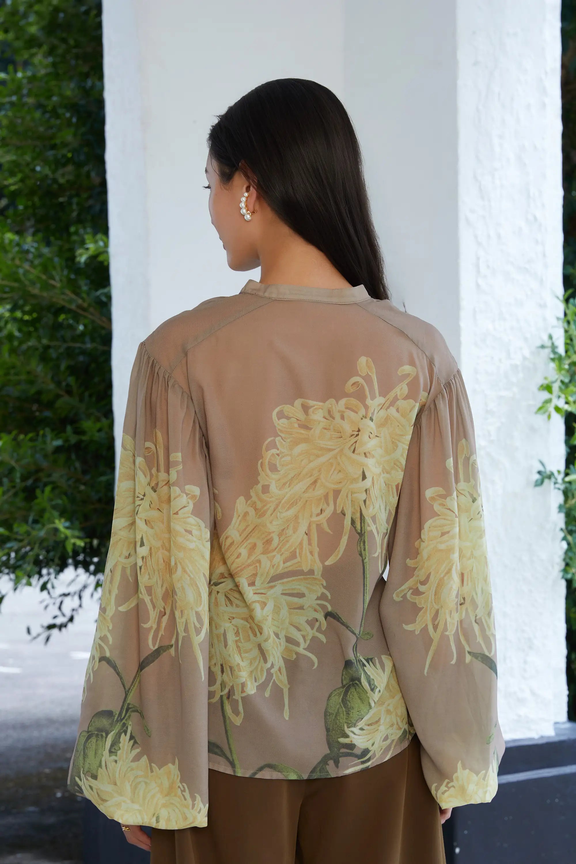 Woman wearing ABIDE sheer floral blouse with relaxed fit (back view)
