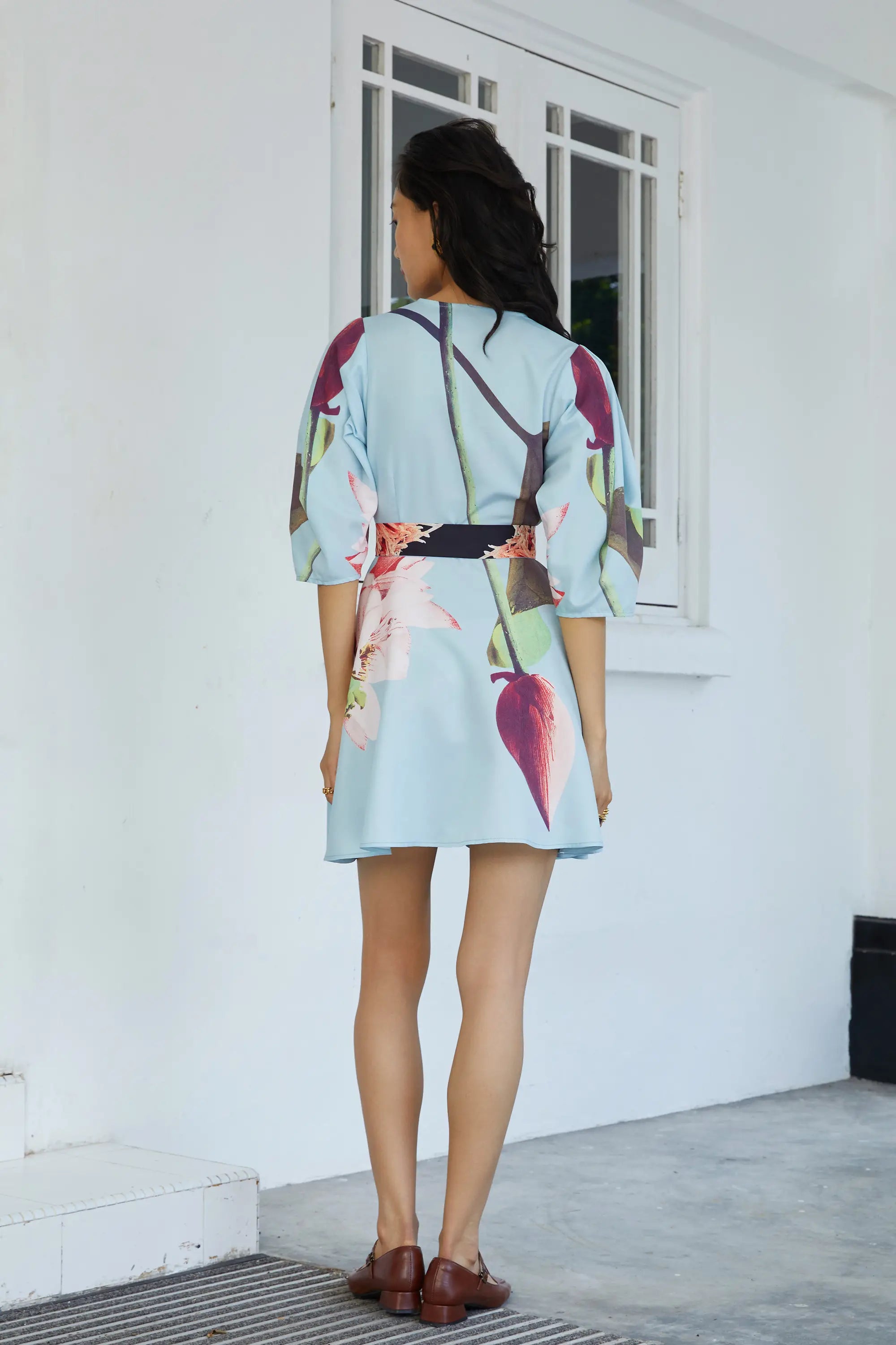 Woman in ABIDE collection placement print dress with relaxed fit (back view)