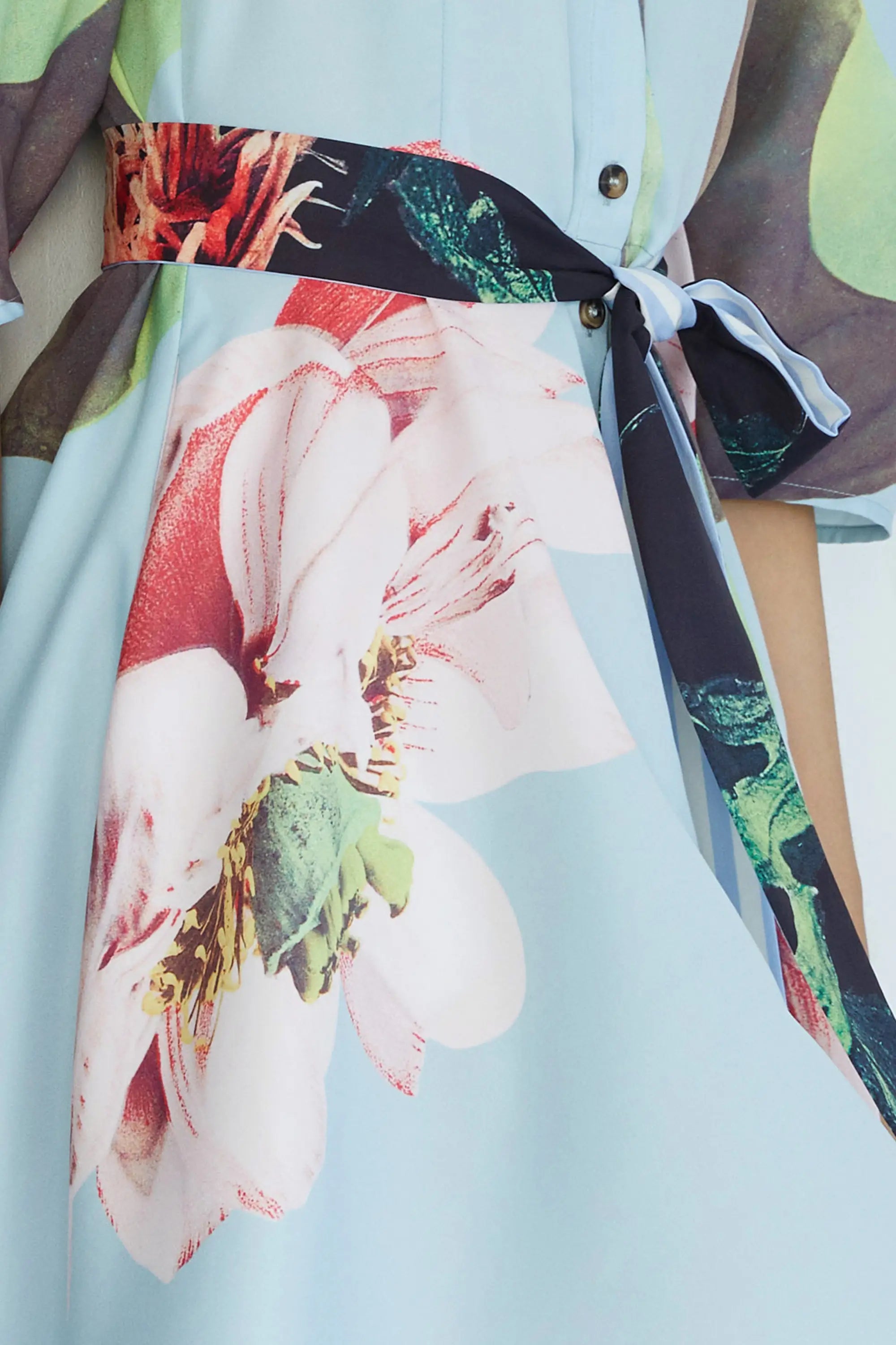 ABIDE placement print mini dress floral print and contrast sash belt detail in light blue (close-up)