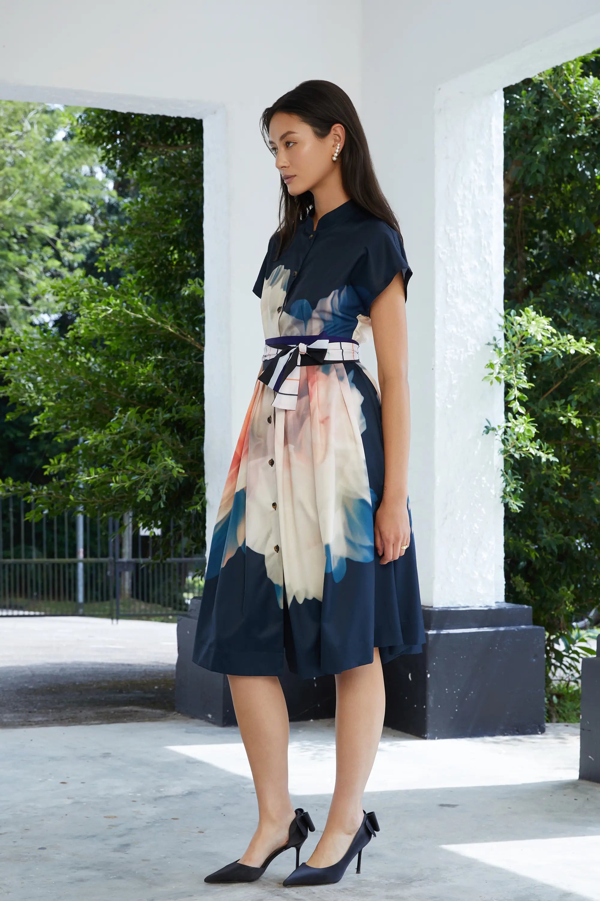 Woman wearing ABIDE placement print dress with sash belt and flutter sleeves (side view)