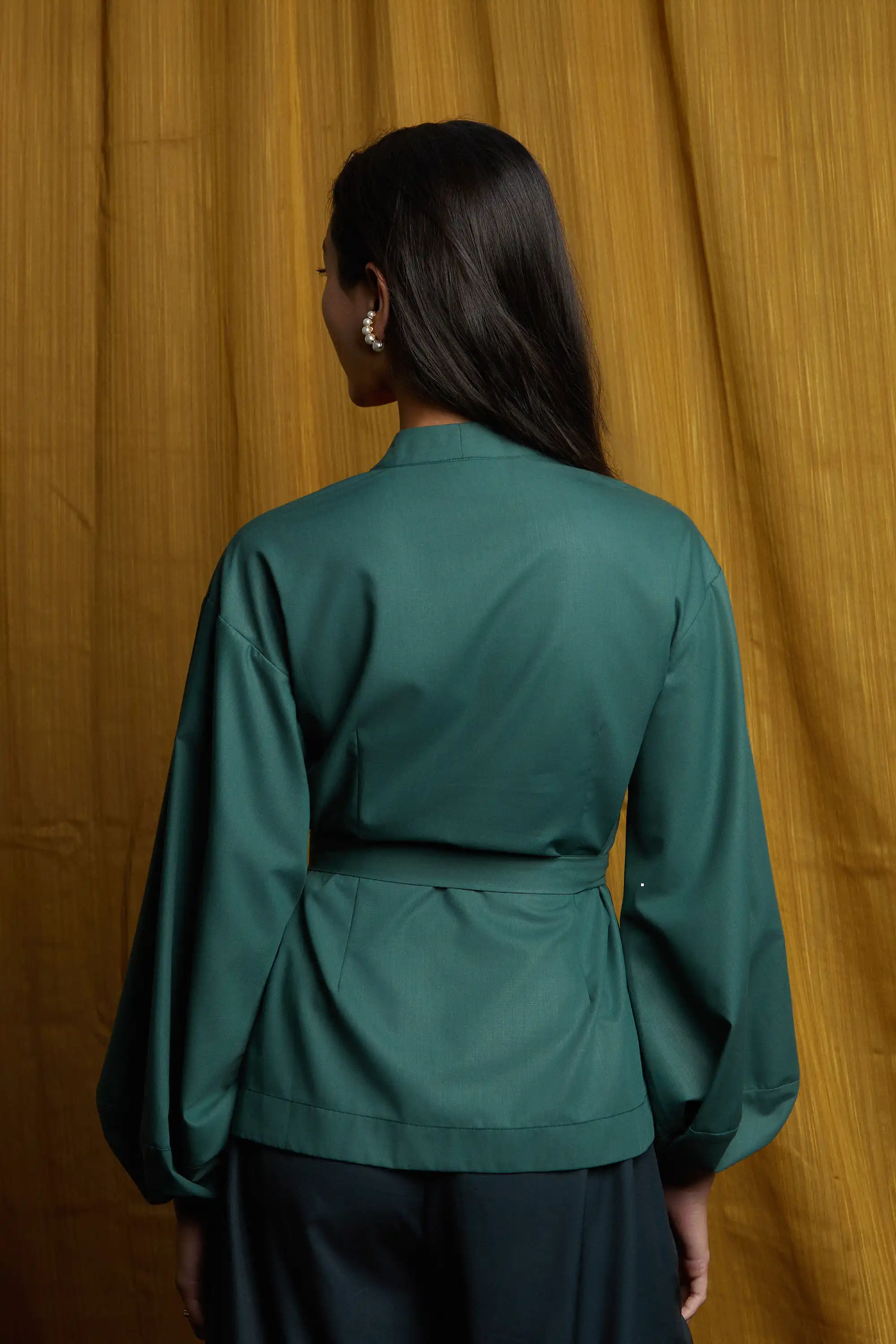 Deep green top with smooth back panel, relaxed fit, and wraparound sash tie for an adjustable, cinched silhouette