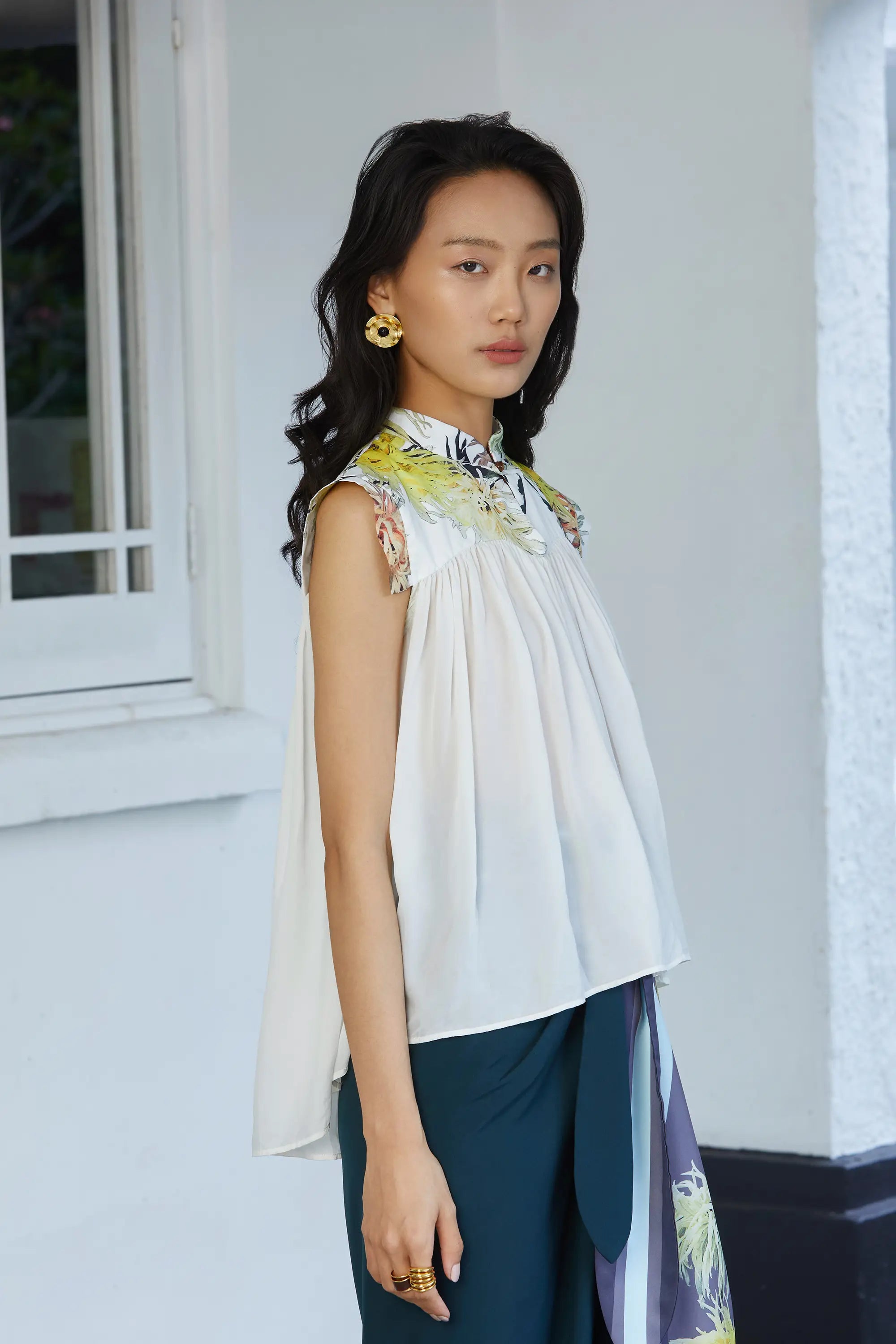 Lightweight blouse with gentle volume and a relaxed fit, showcasing the layered drape and slight high-low hem effect, with the printed collar and cap sleeves framing the shoulders.