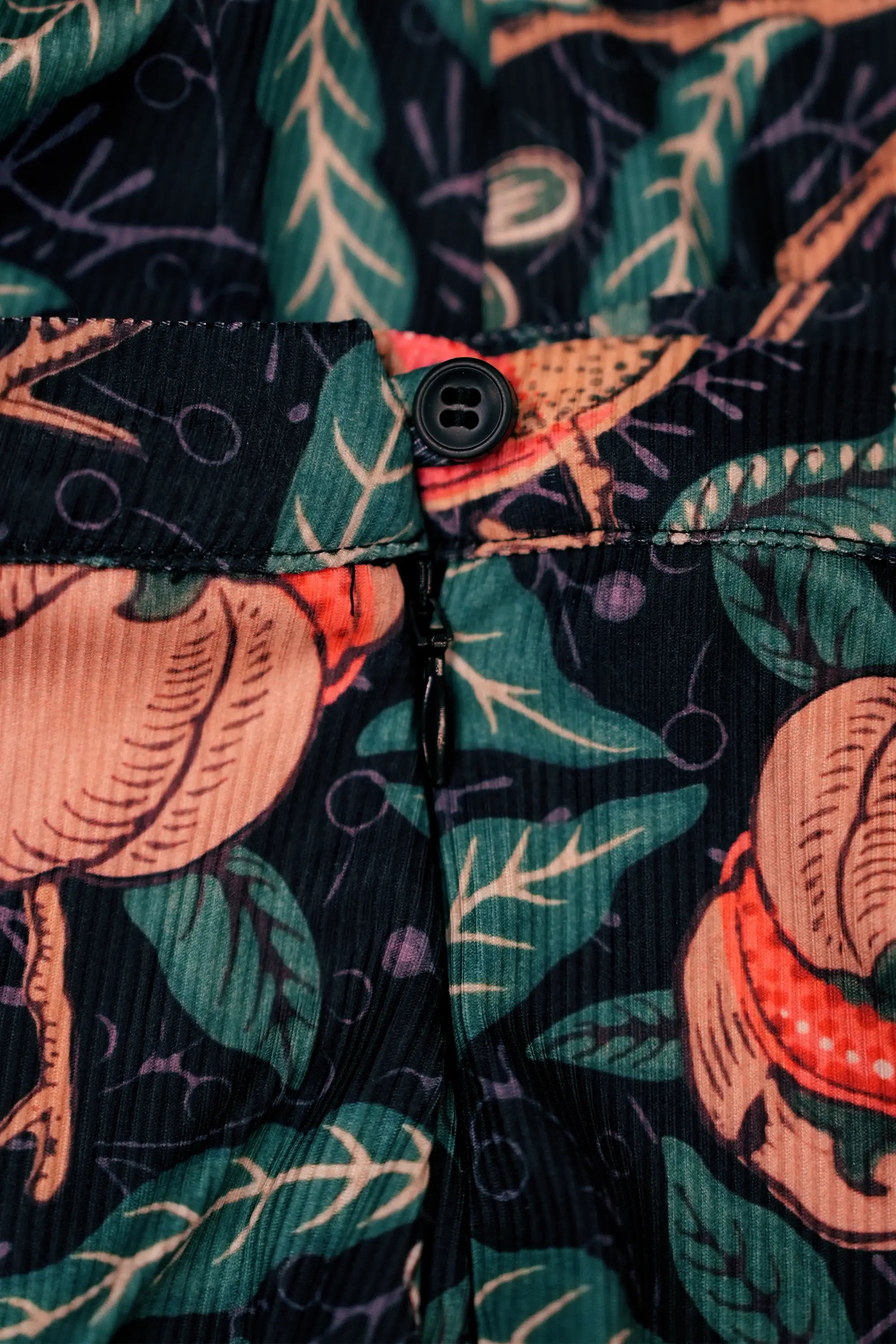 Close-up of button and zip closure on Arrayed black Pomegranate print ribbed midi skirt