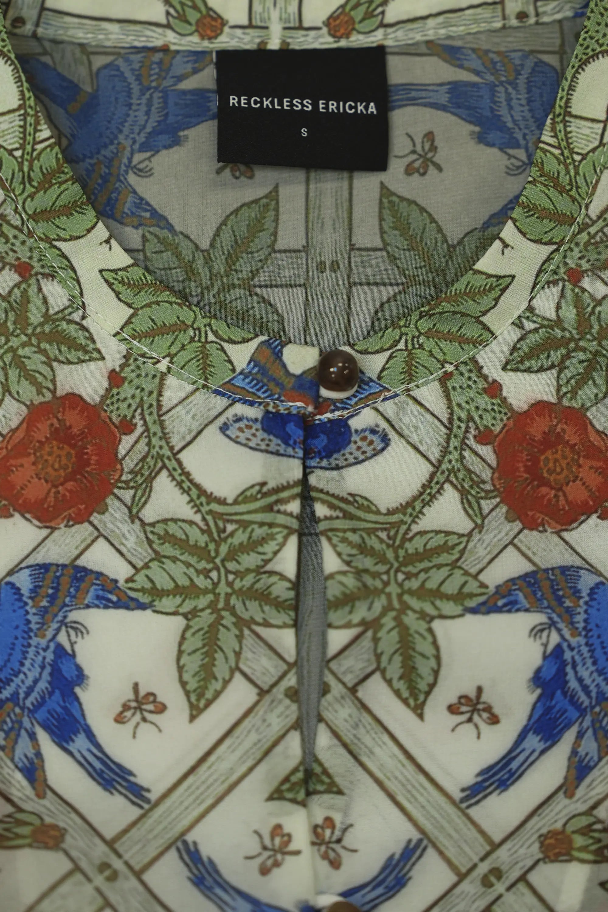 Close-up of keyhole neckline and ball buttons on Arrayed Trellis peplum top