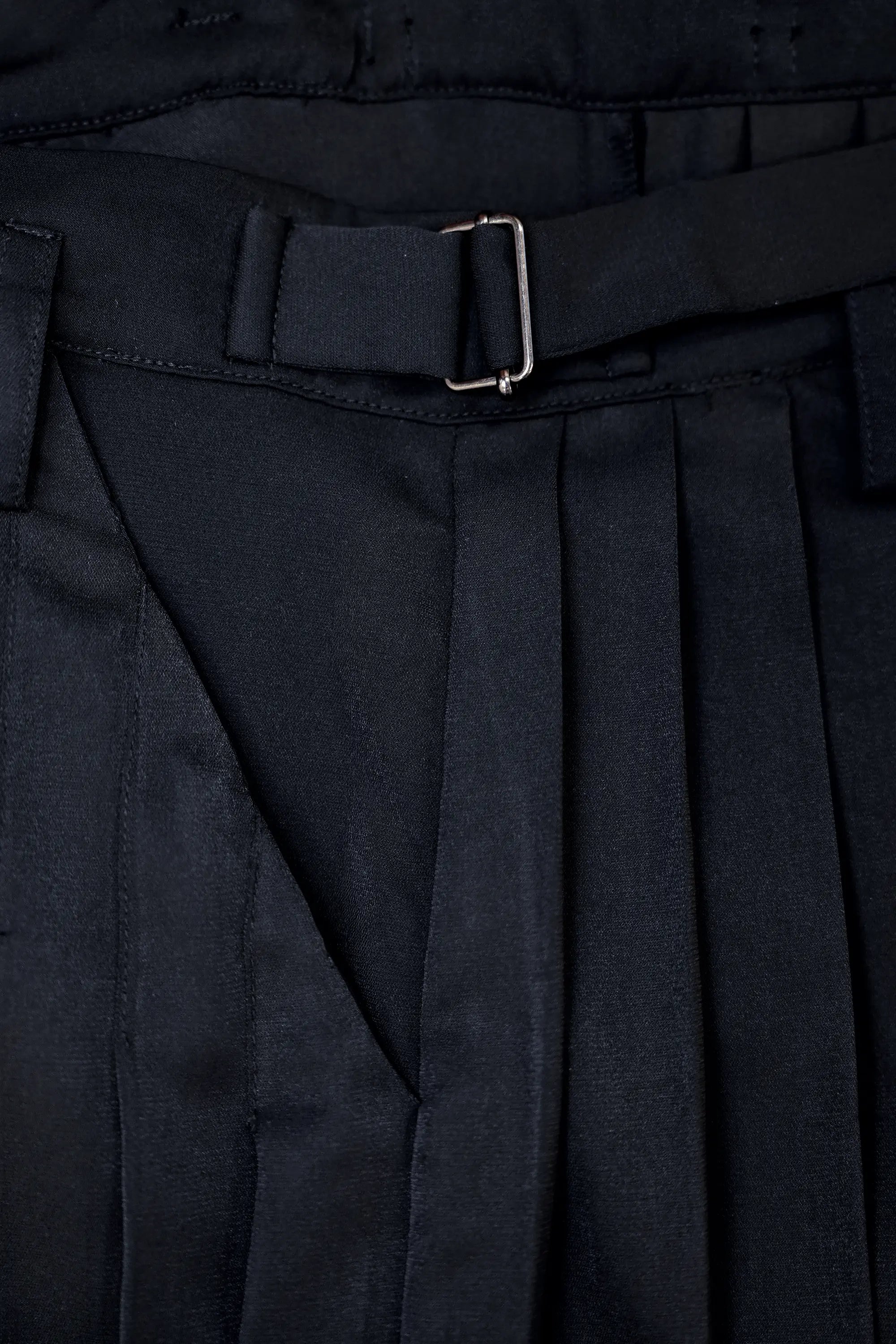 Close-up of buckle on Arrayed black pleated skirt trousers