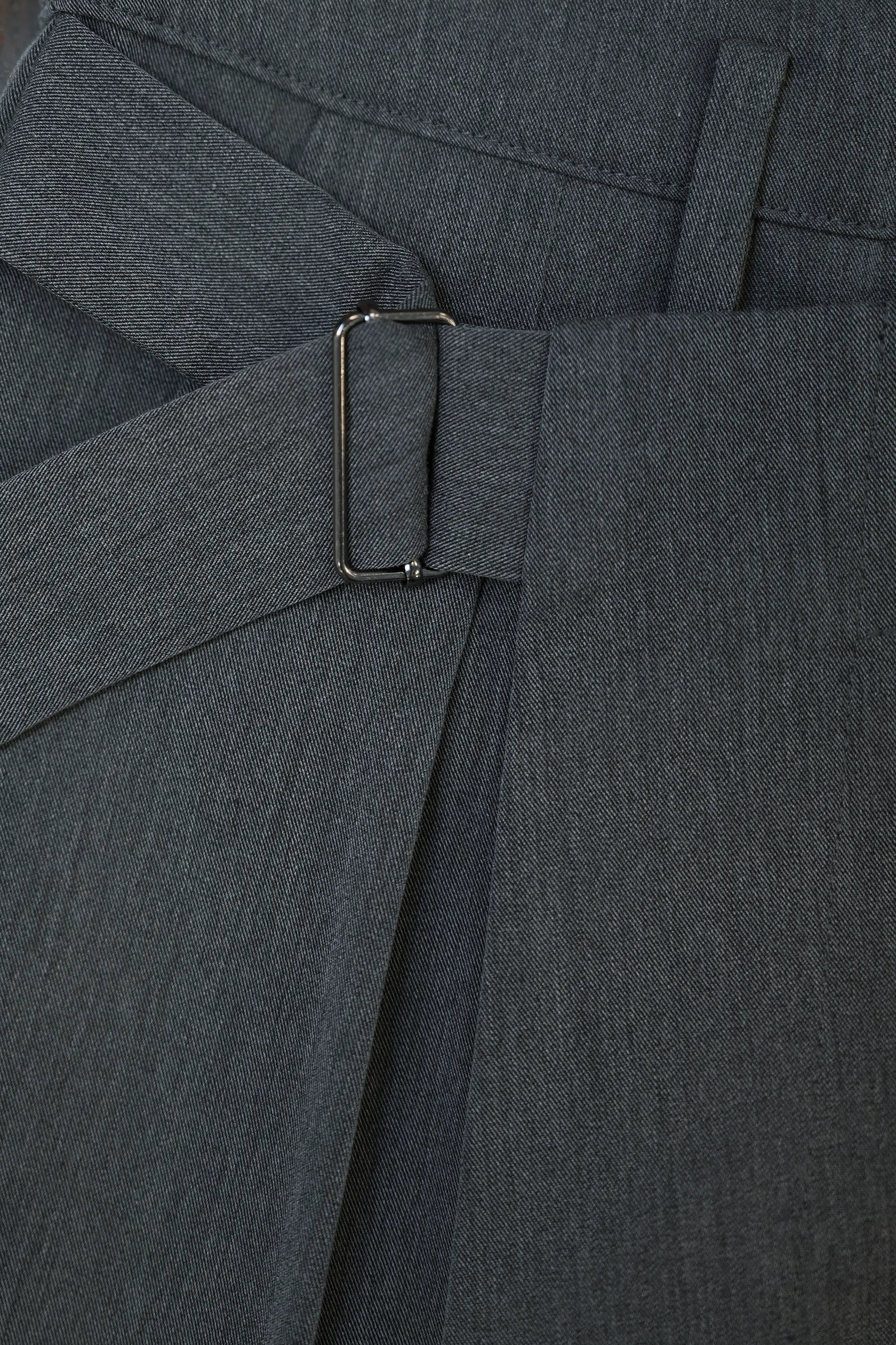 Close-up of side buckle on Arrayed dark grey wrap trousers