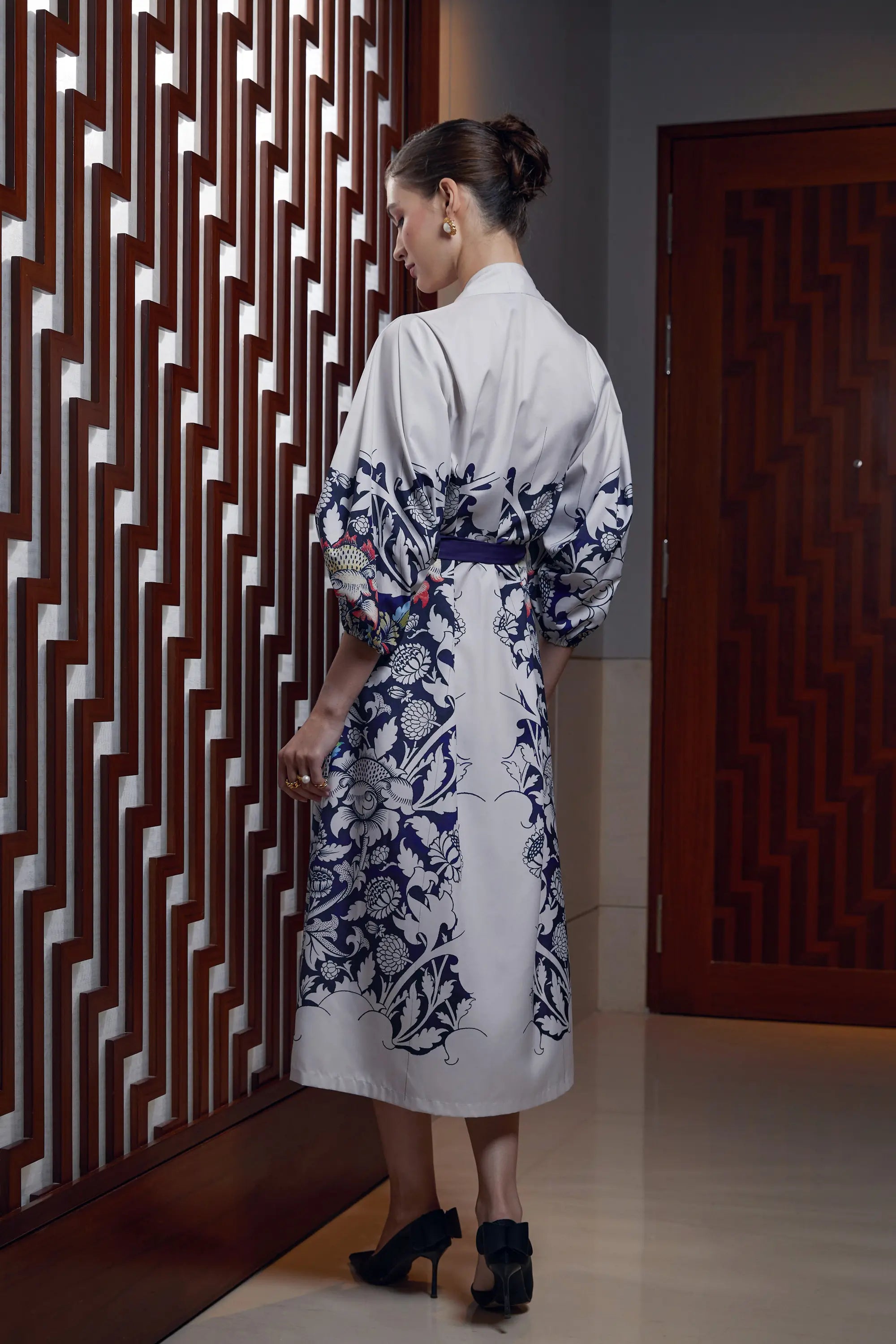 Woman wearing Arrayed Peony print calla sleeve wrap dress in ivory, back view