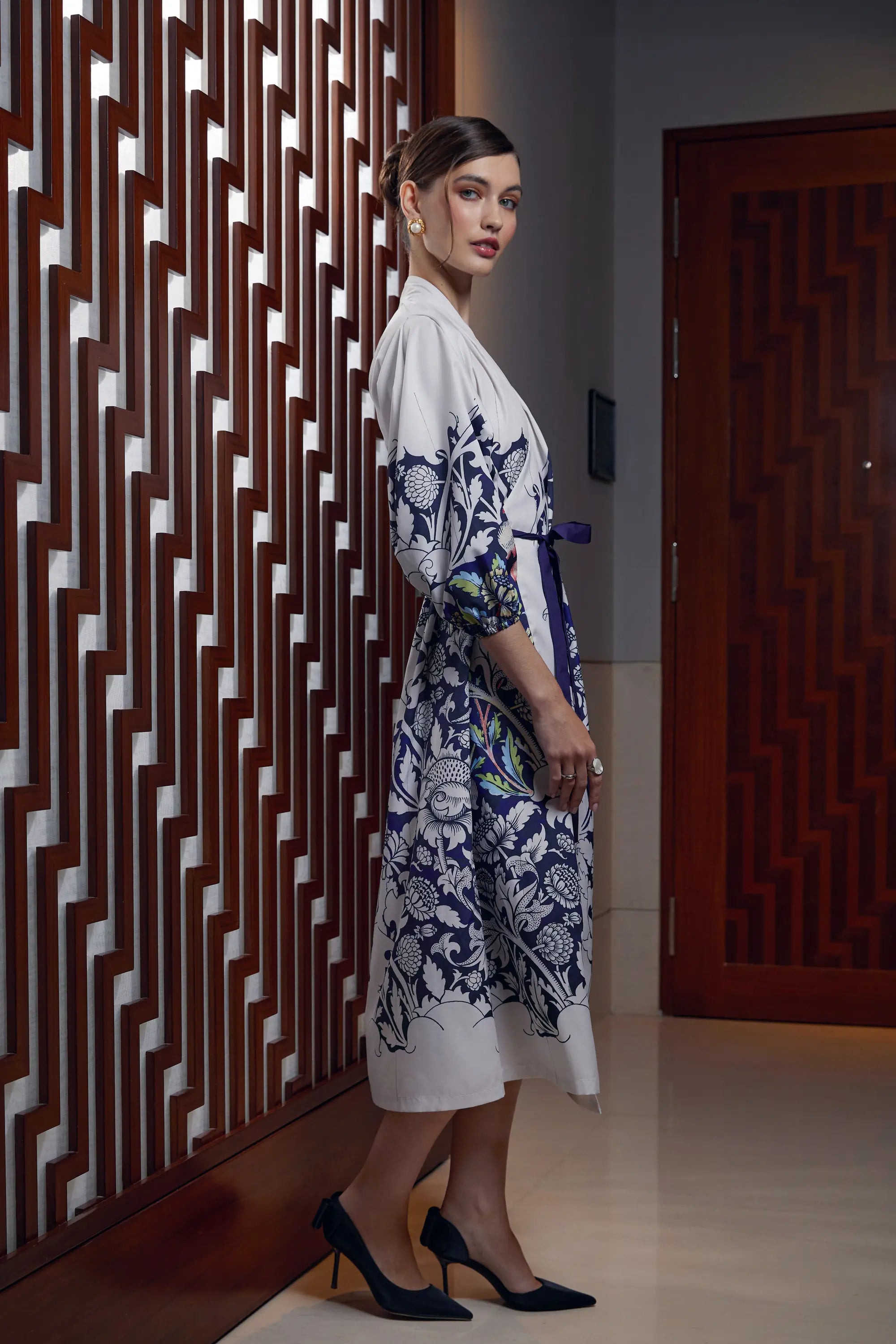 Woman wearing Arrayed Peony wrap dress with voluminous calla sleeves, side view