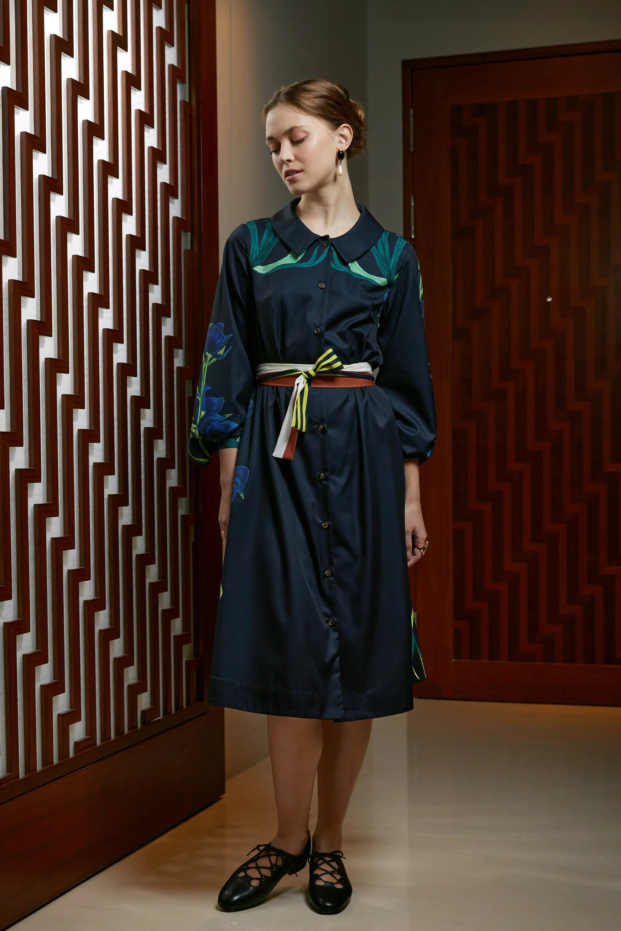 Woman wearing Reckless Ericka Arrayed Monk's Hood print shirt dress in black, front view