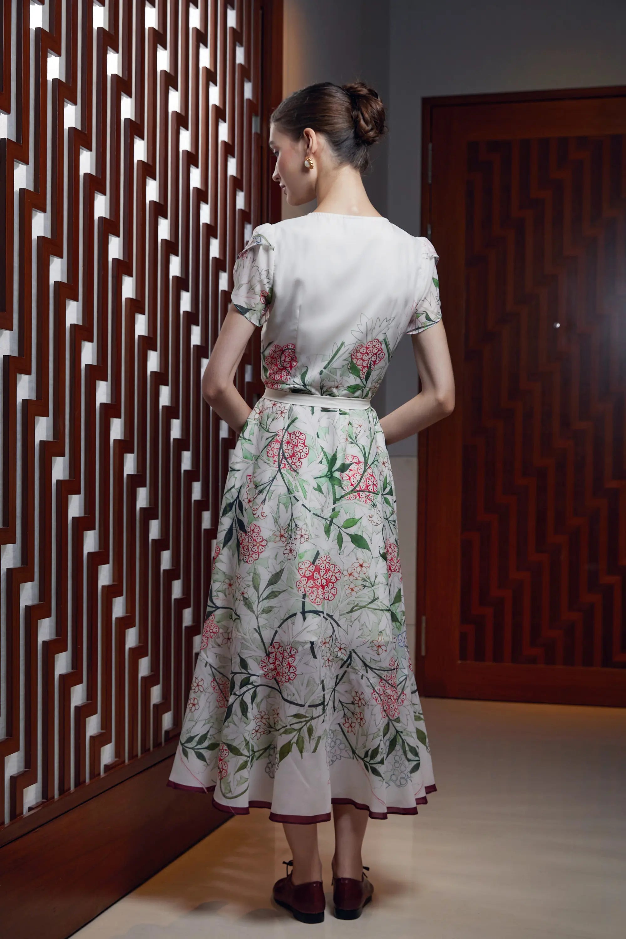 Woman wearing Arrayed Jasmine print mermaid maxi dress in ivory, back view