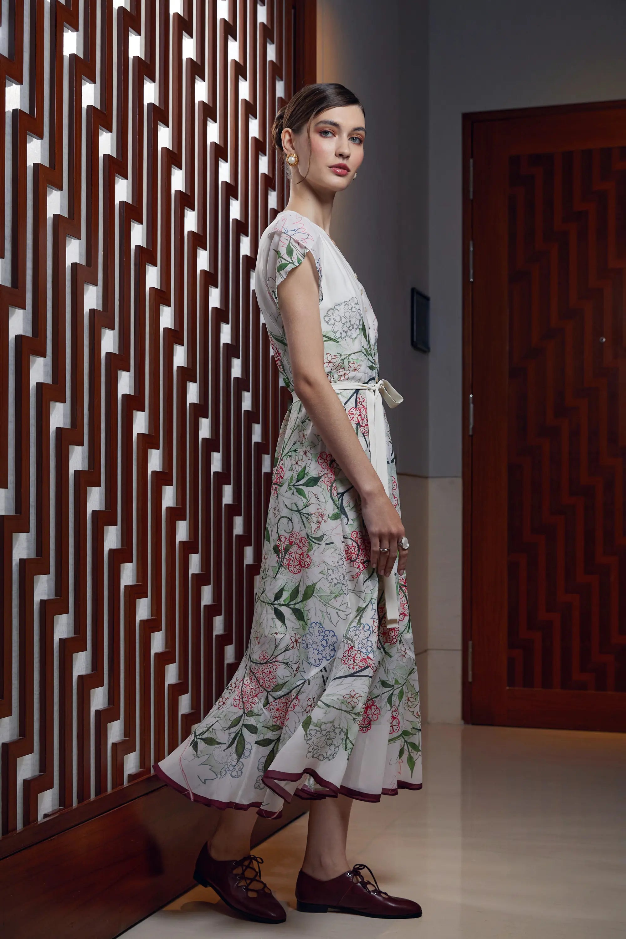 Woman wearing Arrayed Jasmine mermaid maxi dress with petal sleeves, side view