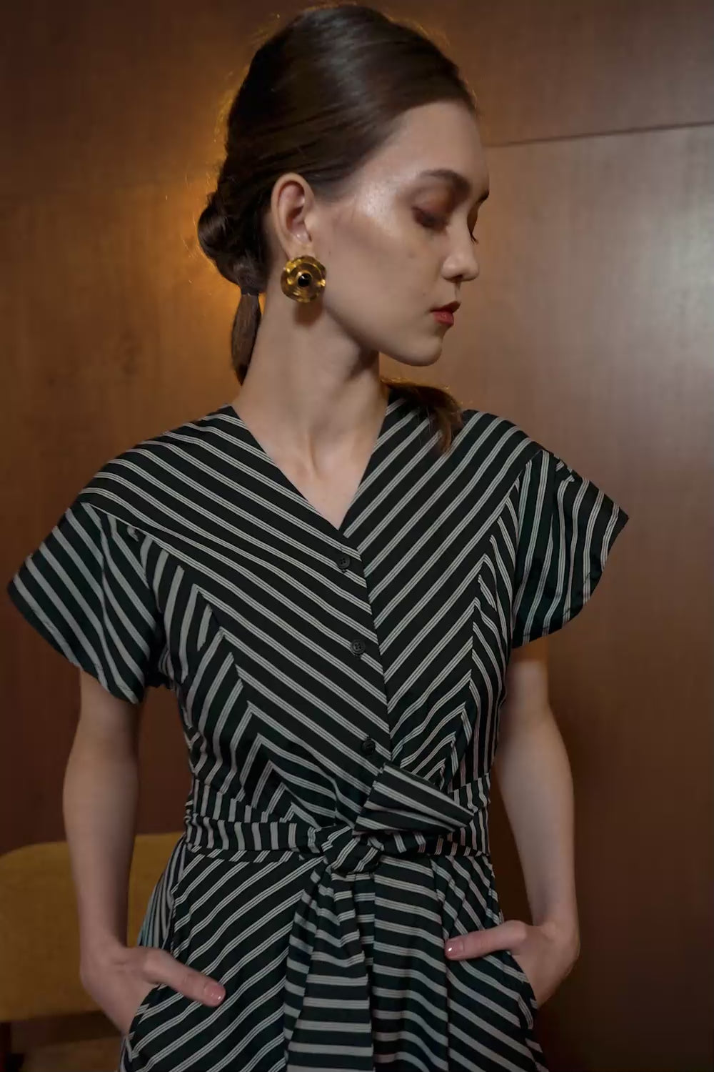 Model in Bluebell Dress with black diagonal stripes — V-neck wrap silhouette with short sleeves and belted waist
