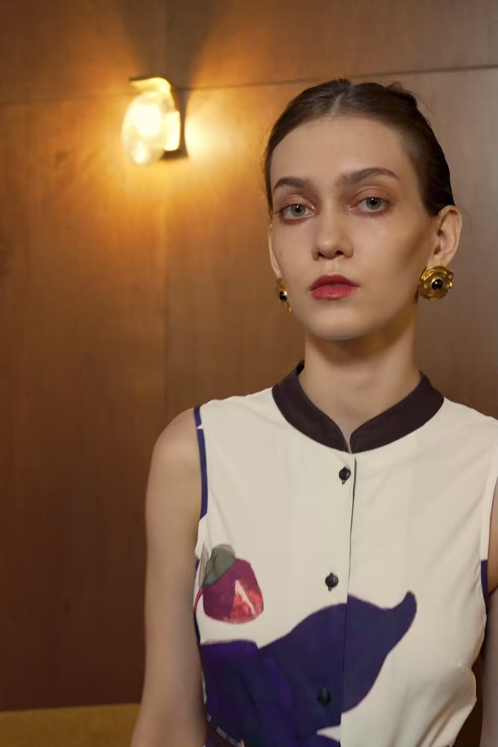 Model in Aquilegia print sleeveless dress with dual pleats and mandarin collar — full floral skirt in motion