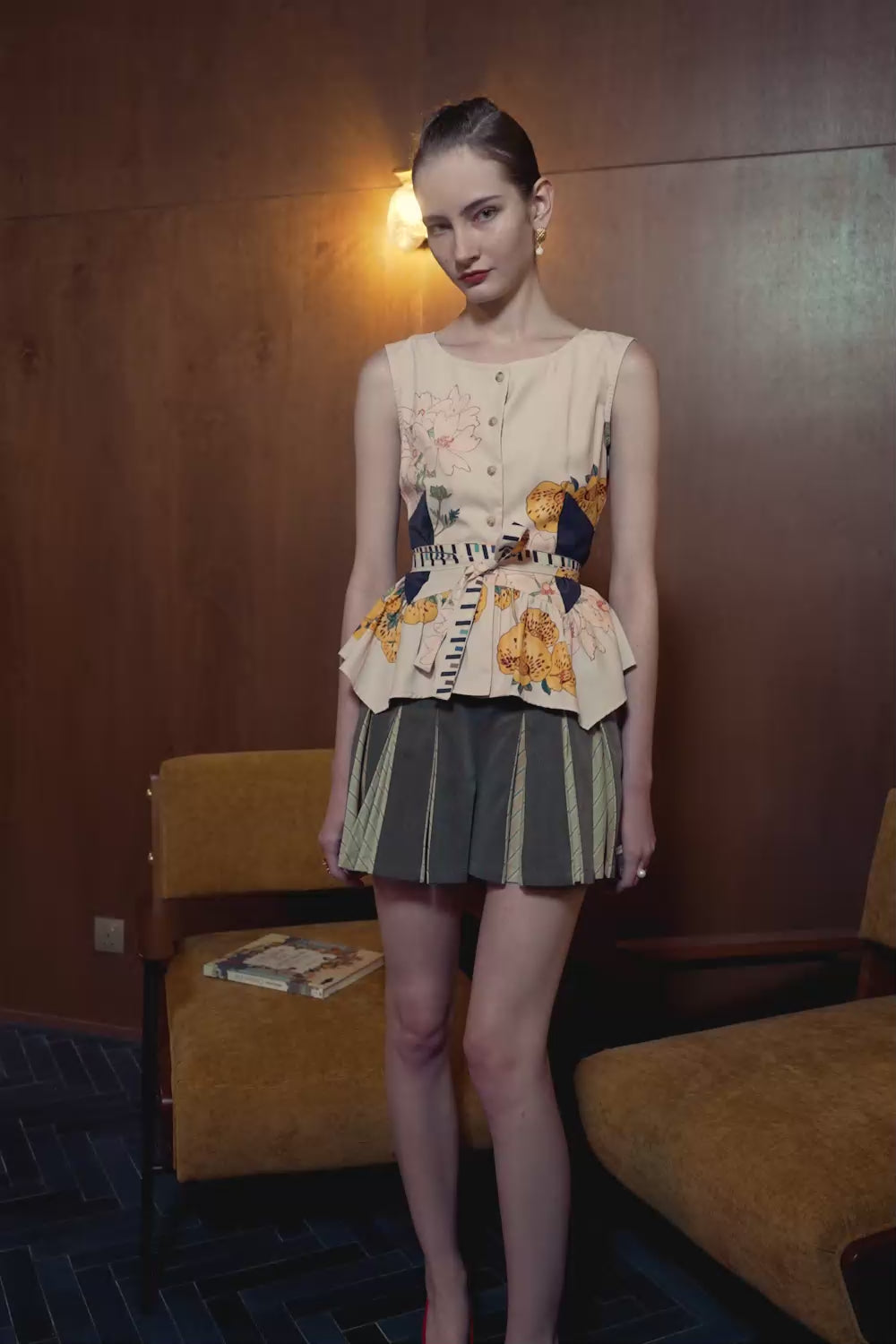 Model in Calceolaria print contour top and striped godet shorts — structured silhouette with soft flare in motion